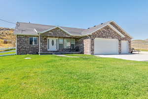 Single story home with a garage, a porch, roof with shingles, and brick siding