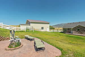 View of yard with a patio, an outbuilding, and a mountain view