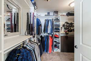 Walk in closet with light colored carpet