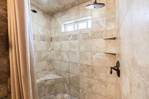 Full bath featuring a tile shower