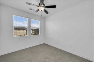 Carpeted spare room featuring baseboards and ceiling fan