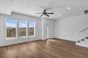 Unfurnished living room with ceiling fan, dark wood-style floors, recessed lighting, and a textured ceiling