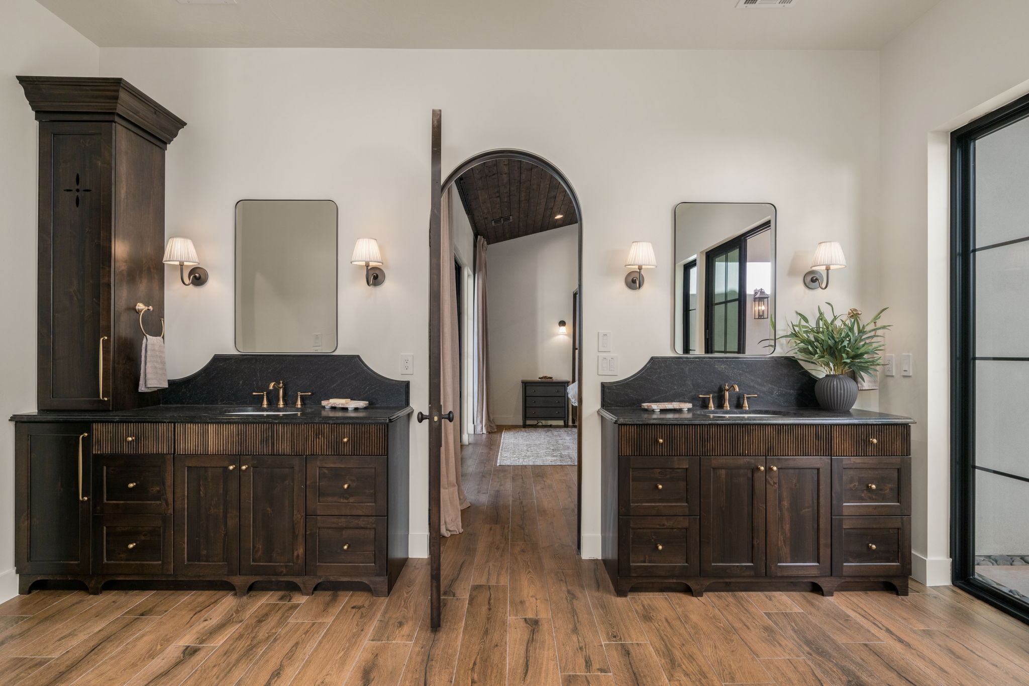 Full bath featuring two vanities and light wood-style flooring