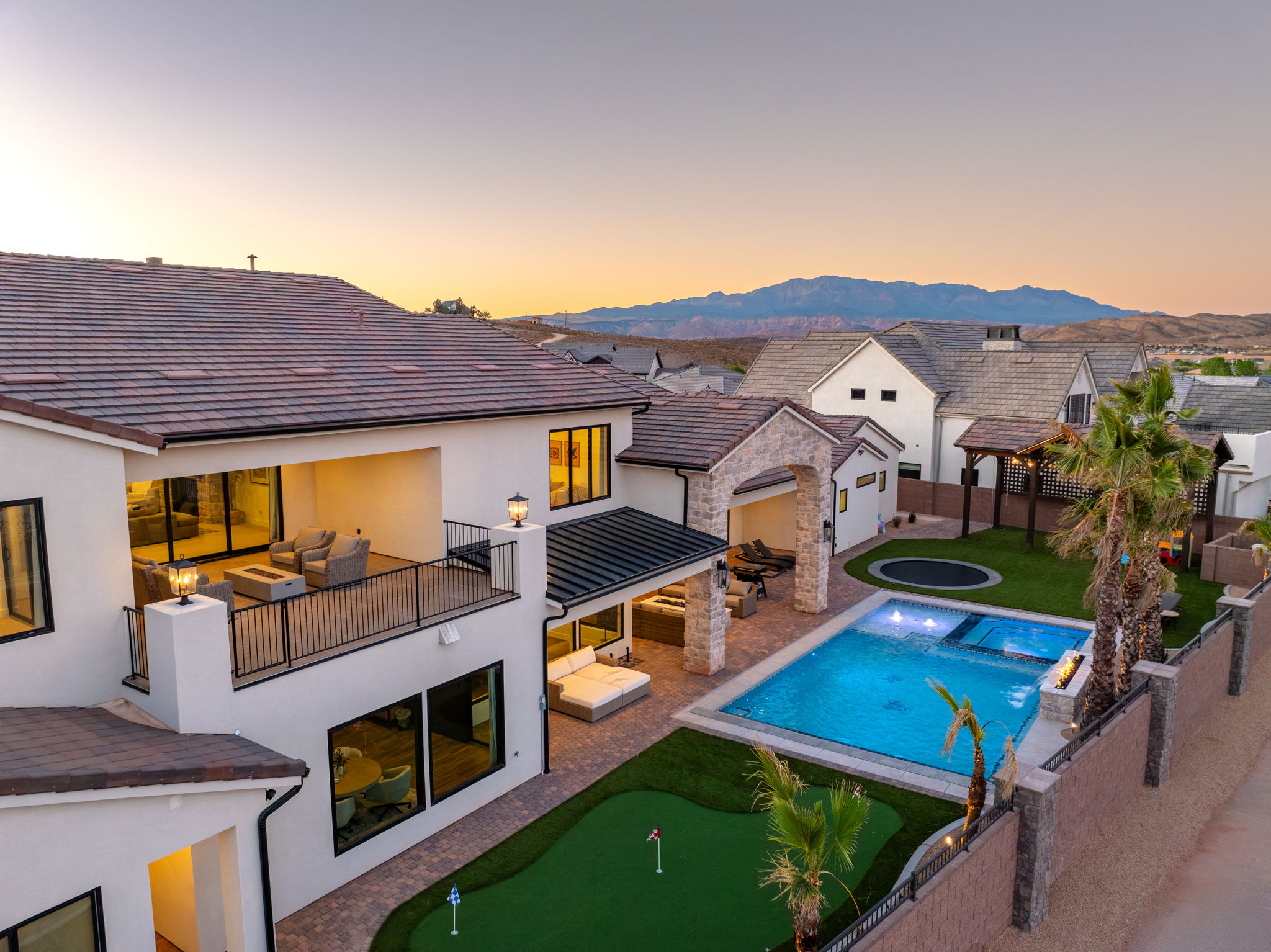 Rear view of property with a patio, stucco siding, a putting area, an outdoor lounge area, and a fenced backyard