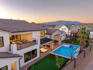Rear view of property with a patio, stucco siding, a putting area, an outdoor lounge area, and a fenced backyard