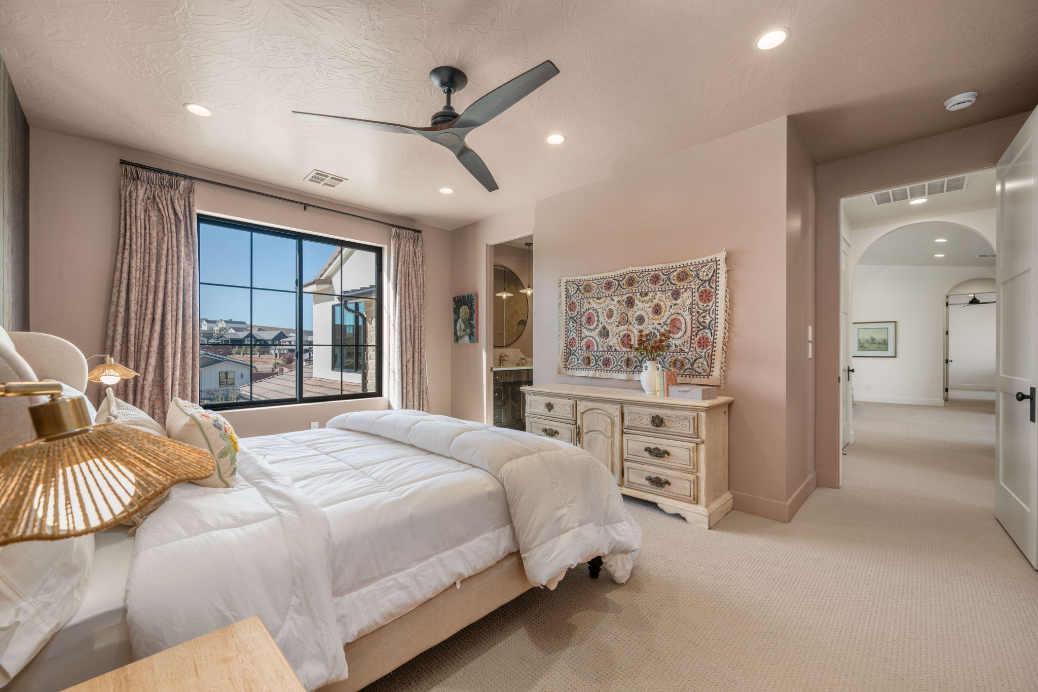 Bedroom with arched walkways, light carpet, a ceiling fan, connected bathroom, and recessed lighting