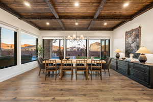 Dining space with a wooden ceiling with exposed beams, suspended lighting, and hardwood / wood-style floors
