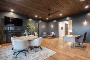 Office space with arched walkways, wood ceiling, a premium fireplace, wood finished floors, and a ceiling fan