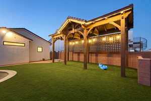 Yard at dusk featuring a fenced backyard and a patio
