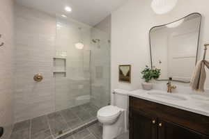 Full bath with vanity, a walk in shower, dark tile patterned flooring, and recessed lighting