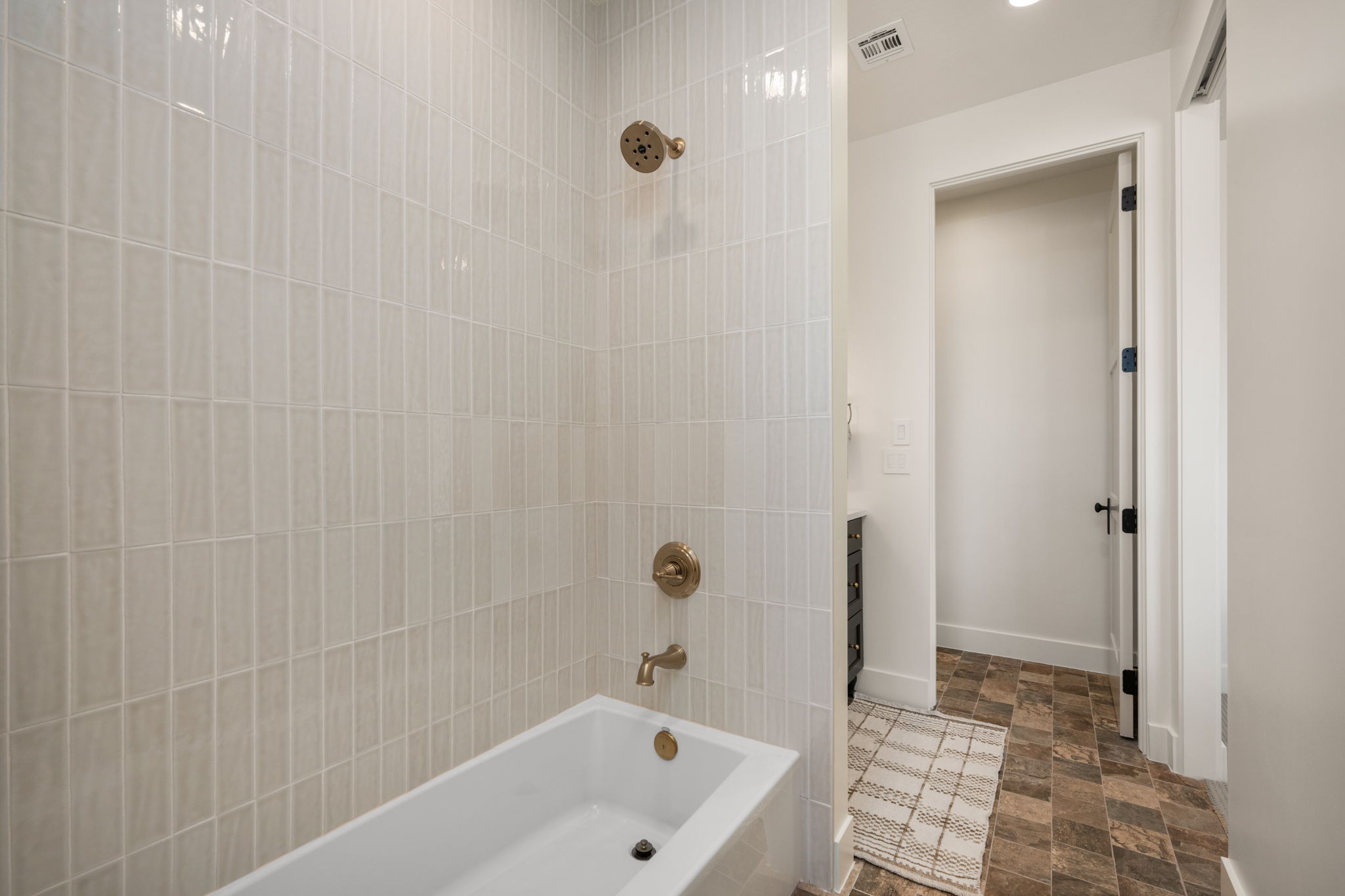 Bathroom with stone finish floors, shower / tub combination, and vanity