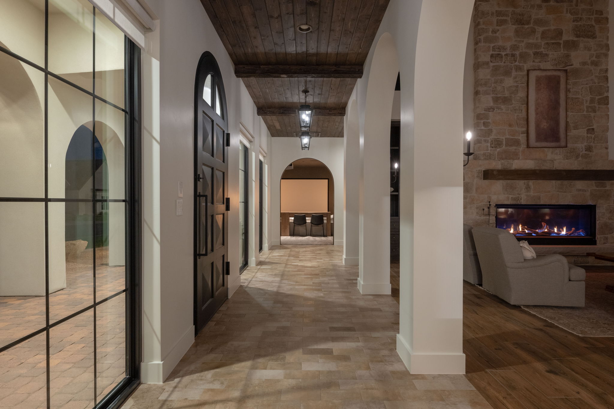 Corridor featuring arched walkways and wooden ceiling