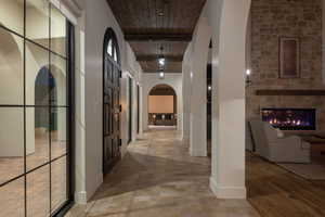 Corridor featuring arched walkways and wooden ceiling