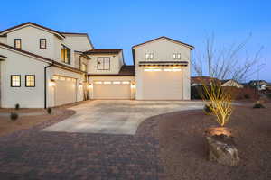 Mediterranean / spanish-style house with concrete driveway, an attached garage, and stucco siding