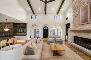 Living area with arched walkways, light wood-style flooring, a fireplace, built in shelves, and recessed lighting