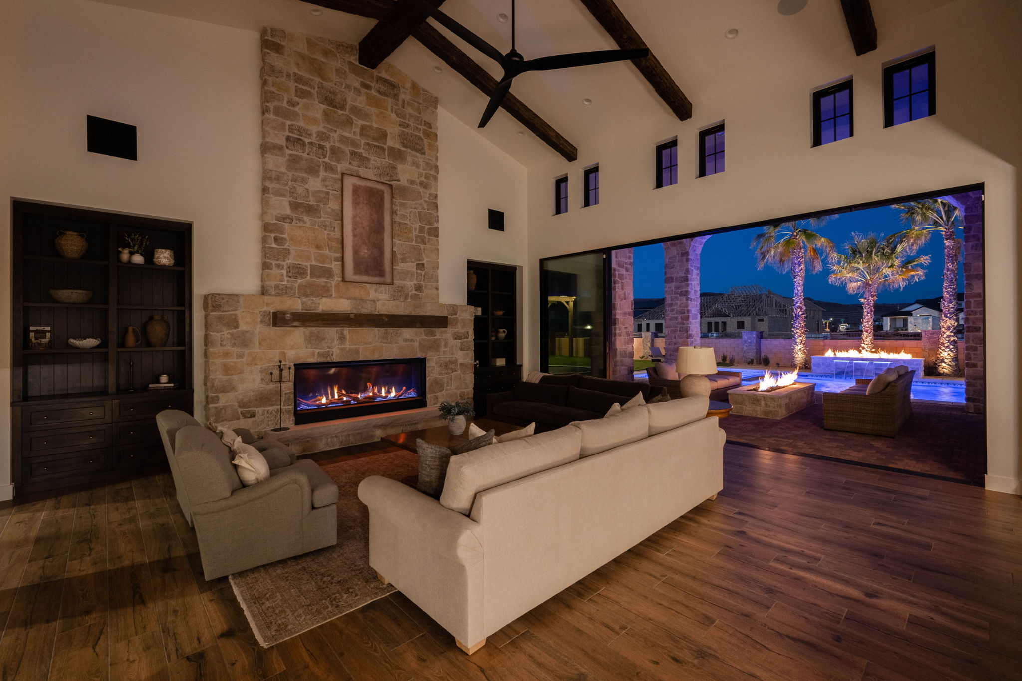 Living area featuring dark wood-style floors, a fireplace, vaulted ceiling, and a ceiling fan