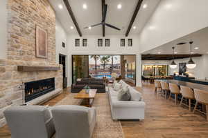 Living room with wood finished floors, a stone fireplace, recessed lighting, and a ceiling fan