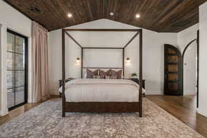 Bedroom with dark wood-style flooring, wood ceiling, access to exterior, arched walkways, and recessed lighting