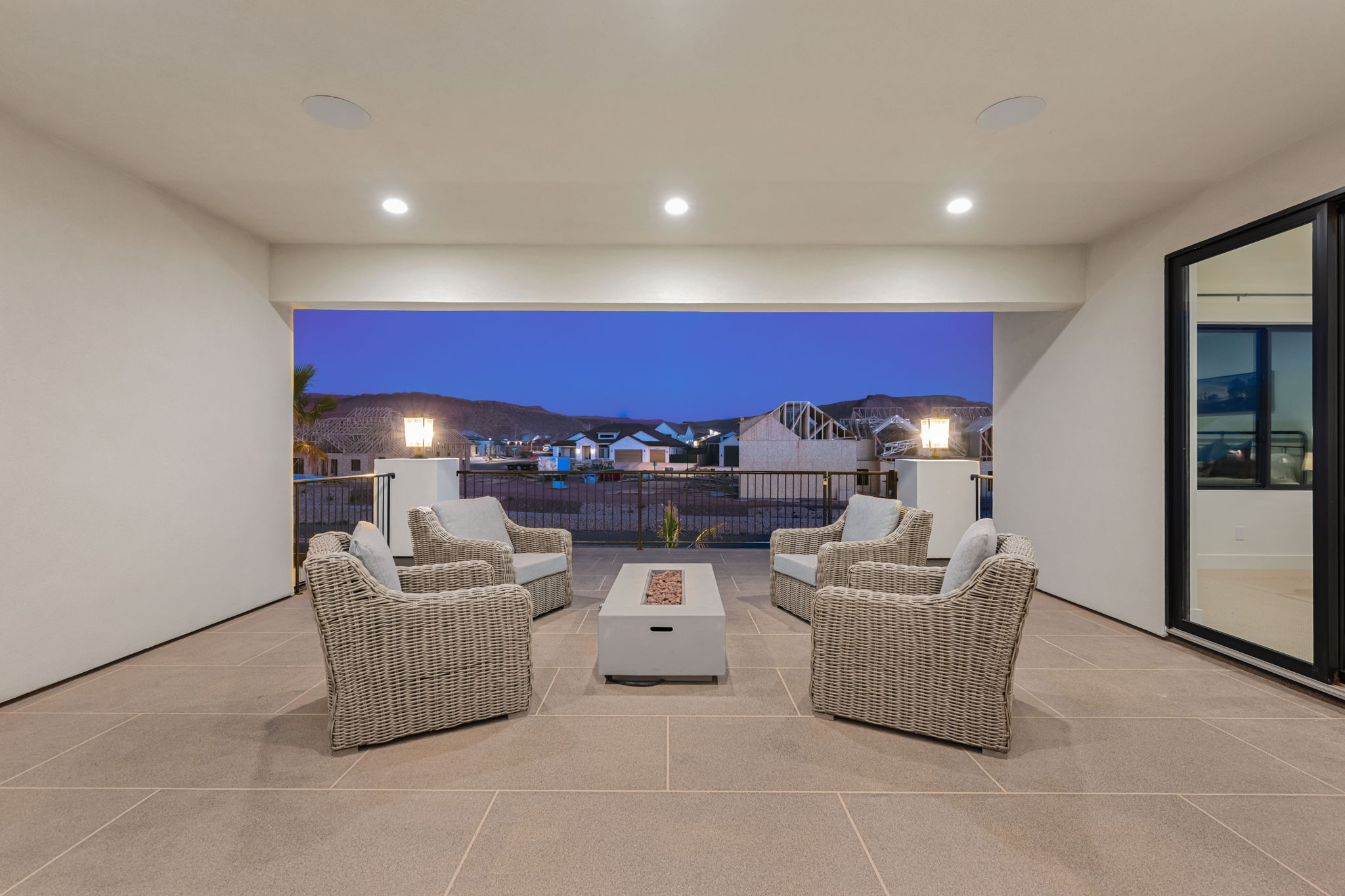 Patio at night featuring a patio area, an outdoor living space with a fire pit, and a residential view