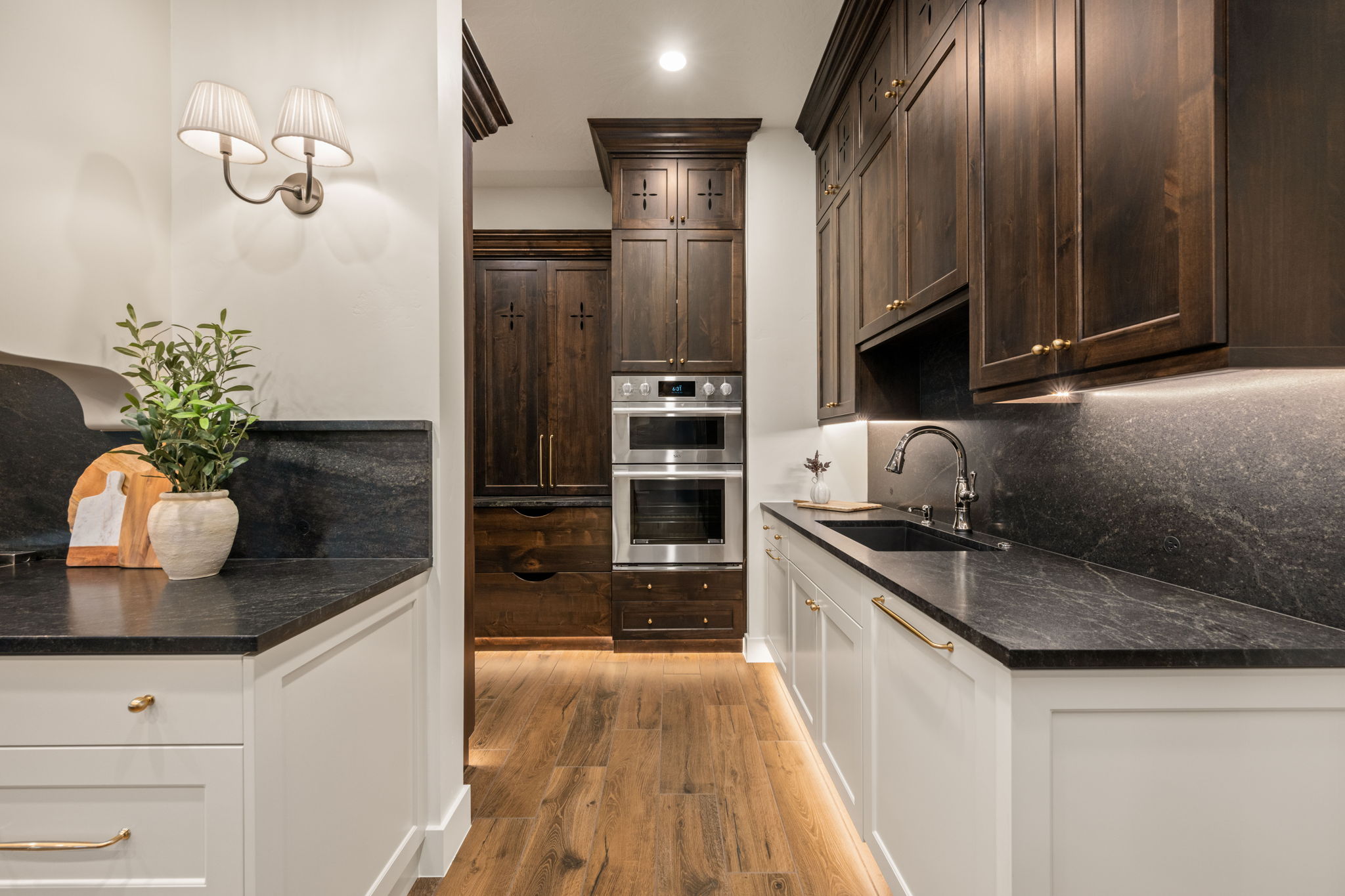 Kitchen featuring recessed lighting, double oven, dark stone counters, light wood-type flooring, and tasteful backsplash