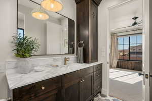 Bathroom featuring vanity, healthy amount of natural light, a ceiling fan, and light colored carpet