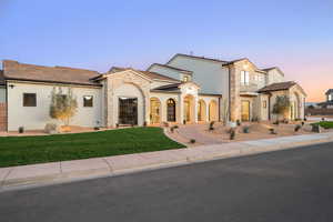 View of front facade featuring stone siding, stucco siding, and a yard