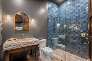 Bathroom featuring a tile shower and vanity