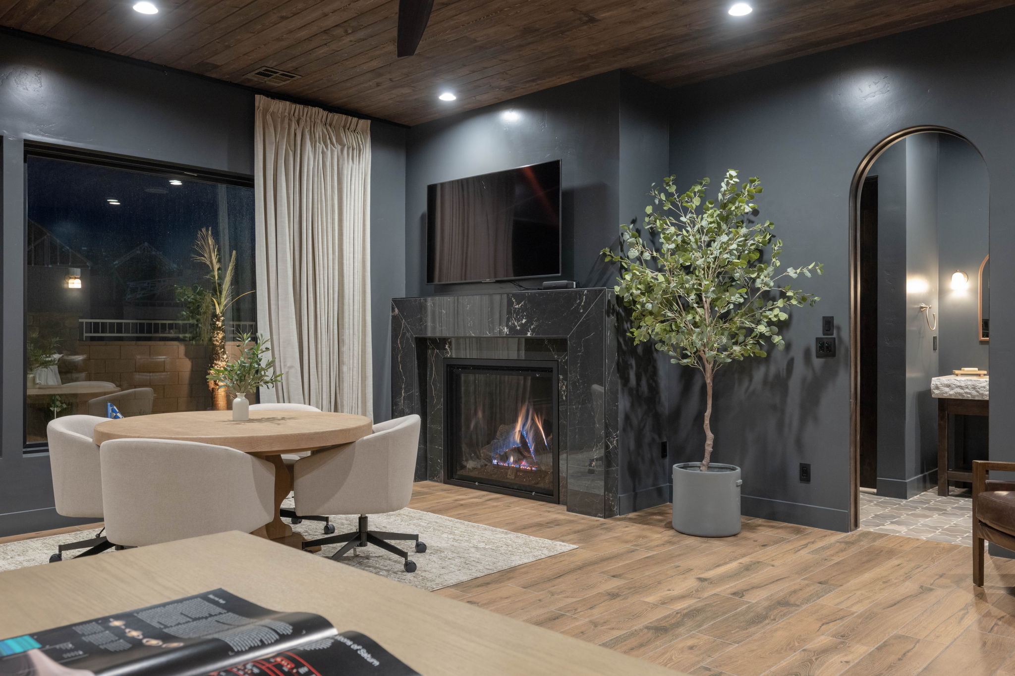 Living room featuring arched walkways, light wood finished floors, recessed lighting, a premium fireplace, and wooden ceiling