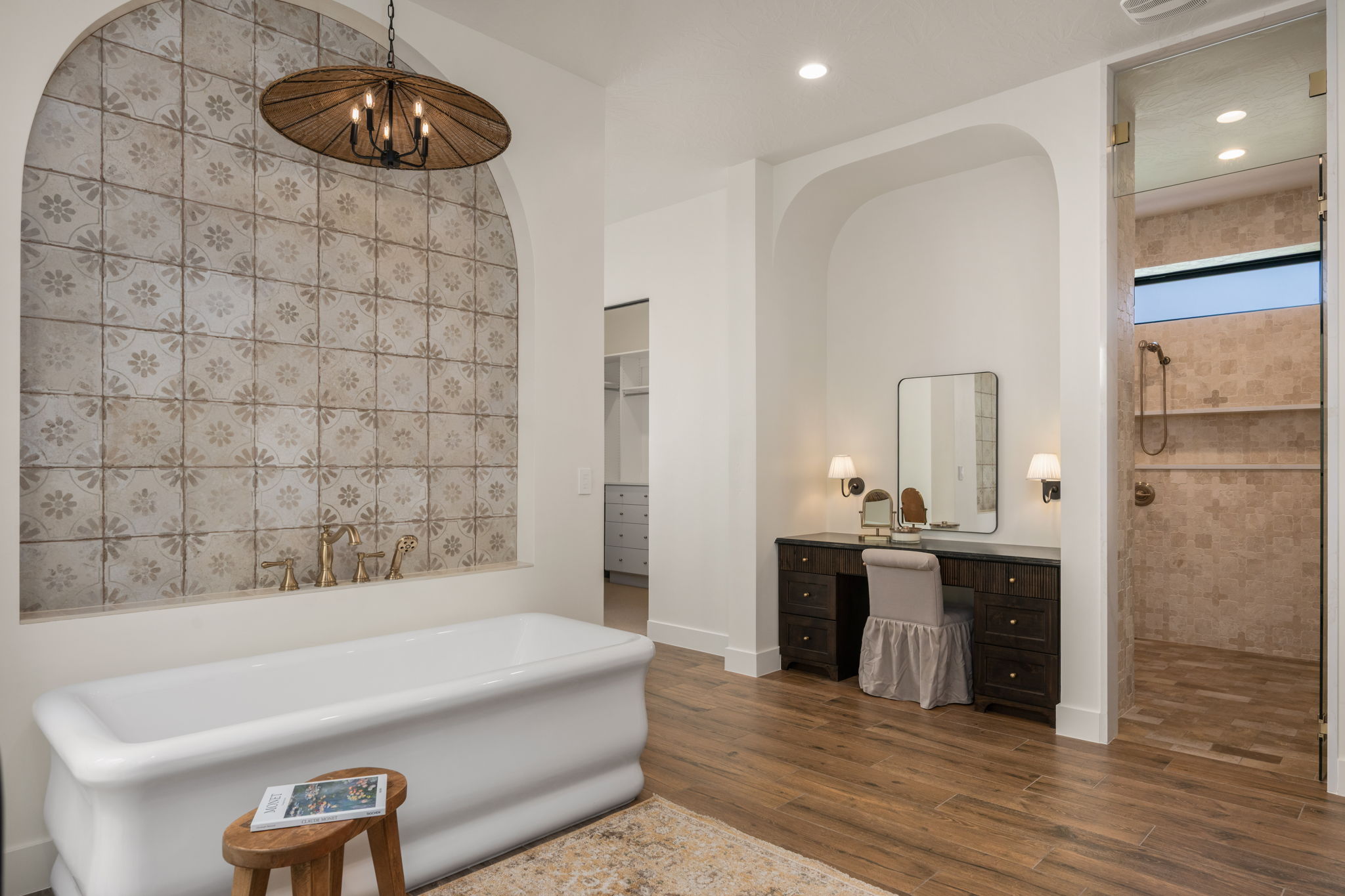 Bathroom with vanity, dark wood finished floors, a freestanding tub, a walk in closet, and a tile shower