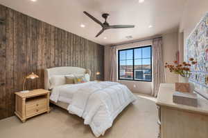 Bedroom with light carpet, a ceiling fan, recessed lighting, and wood walls