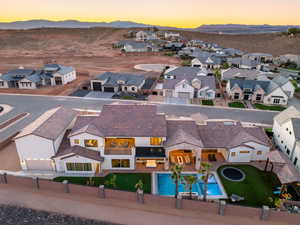 Aerial view at dusk of view of pool area, a residential view, and a mountain view