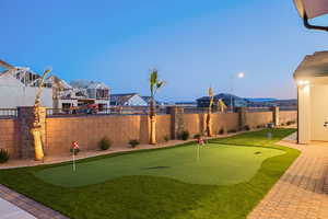 Fenced backyard featuring a putting area