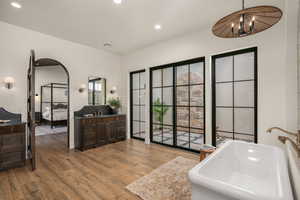 Ensuite bathroom featuring vanity, dark wood-style floors, a tub to relax in, and recessed lighting