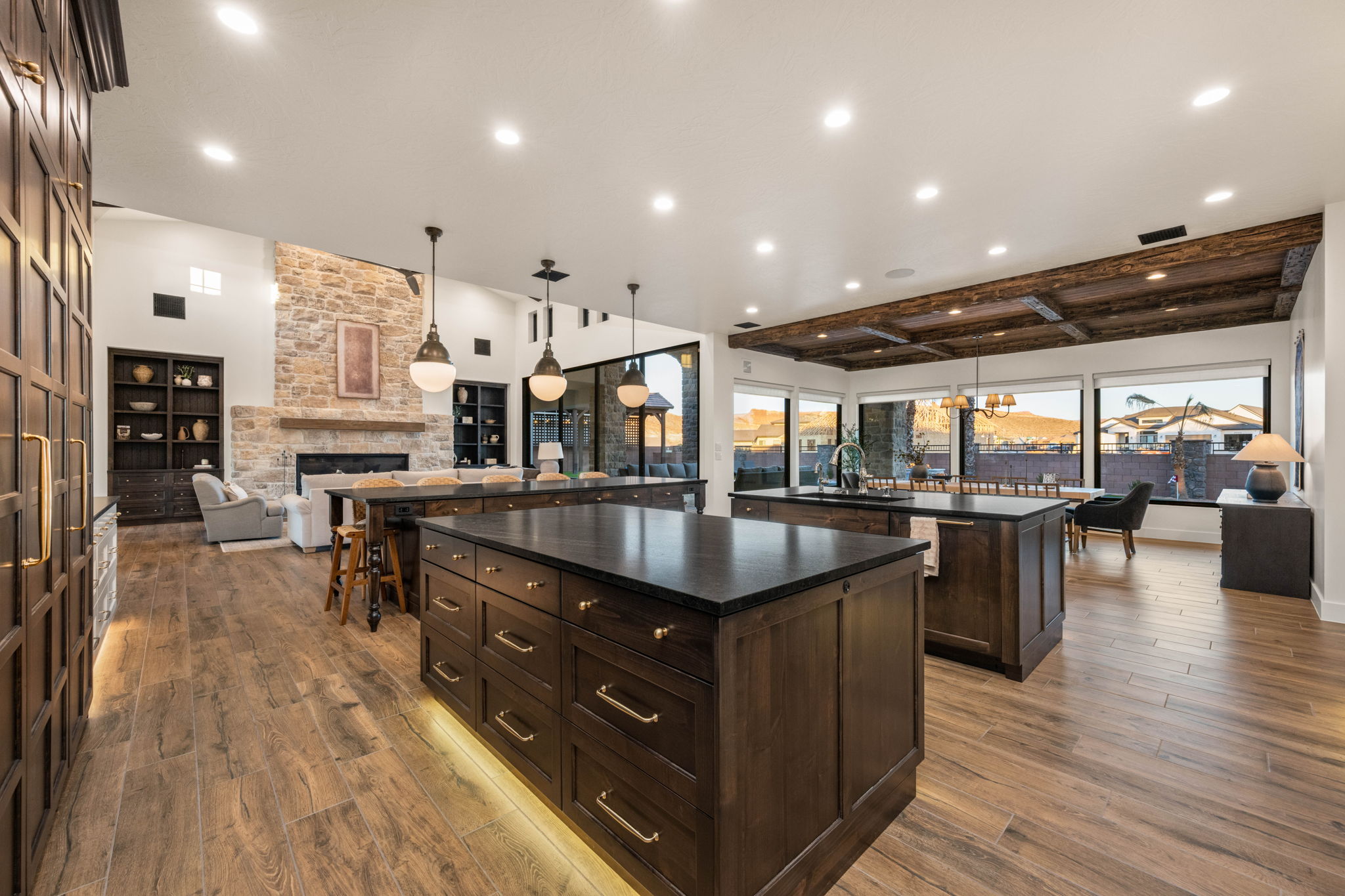 Kitchen featuring open floor plan, dark wood finish cabinetry, a fireplace, pendant lighting, and light wood finished floors