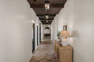 Hallway featuring arched walkways and wood ceiling