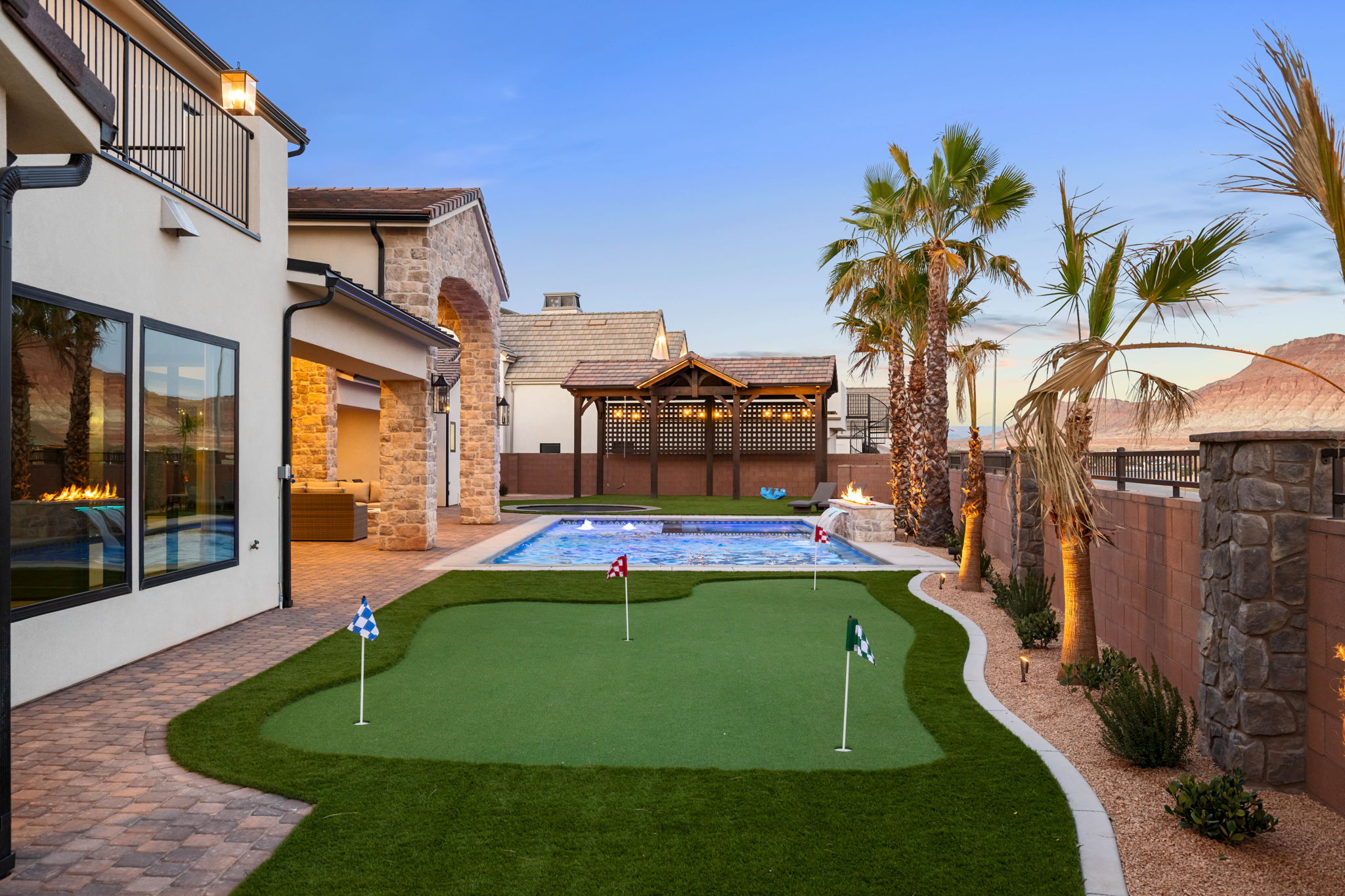 Fenced backyard with a patio and a putting area
