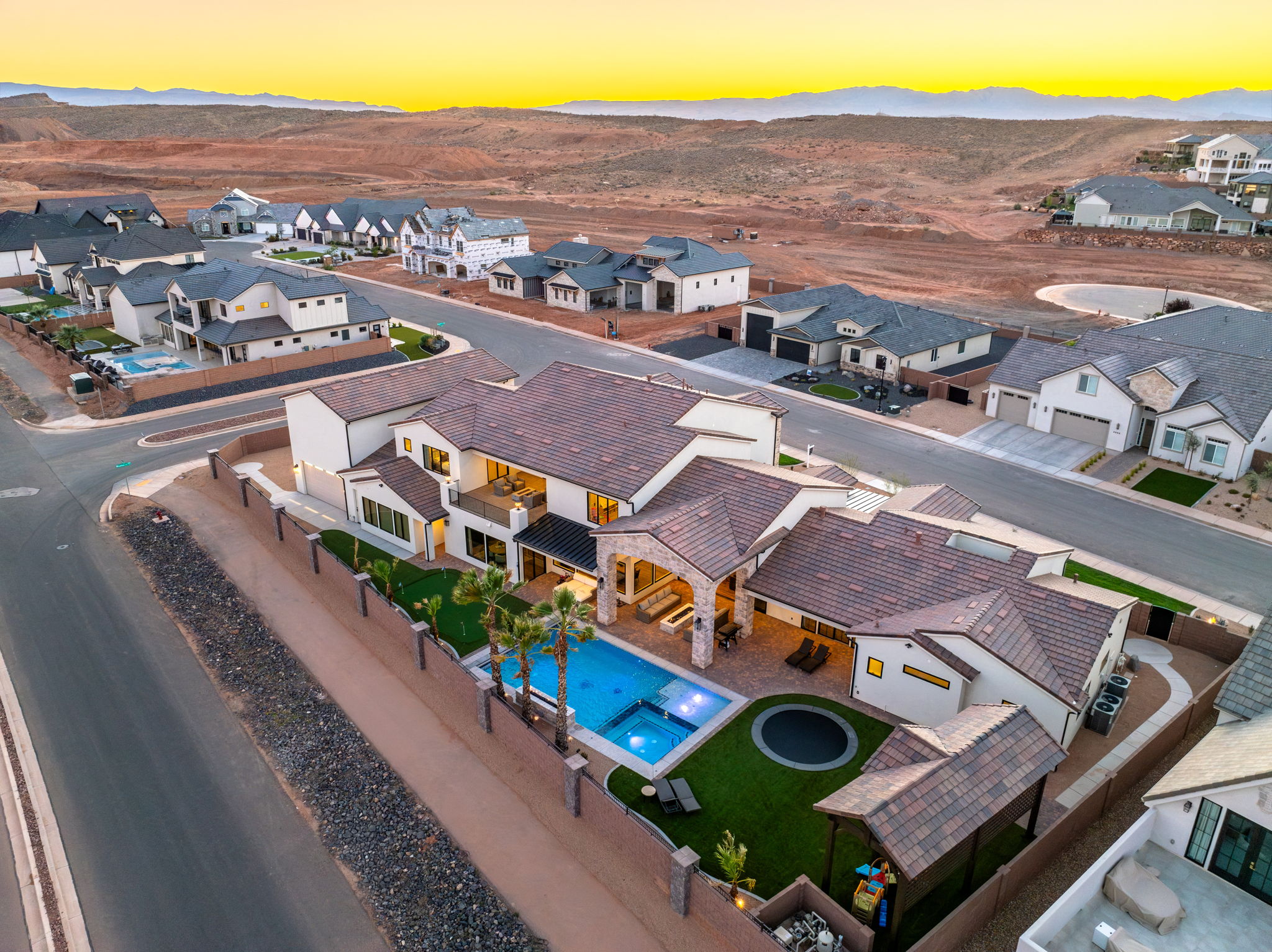 Aerial view at dusk of a residential view, view of pool area, and a mountain view