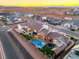 Aerial view at dusk of a residential view, view of pool area, and a mountain view