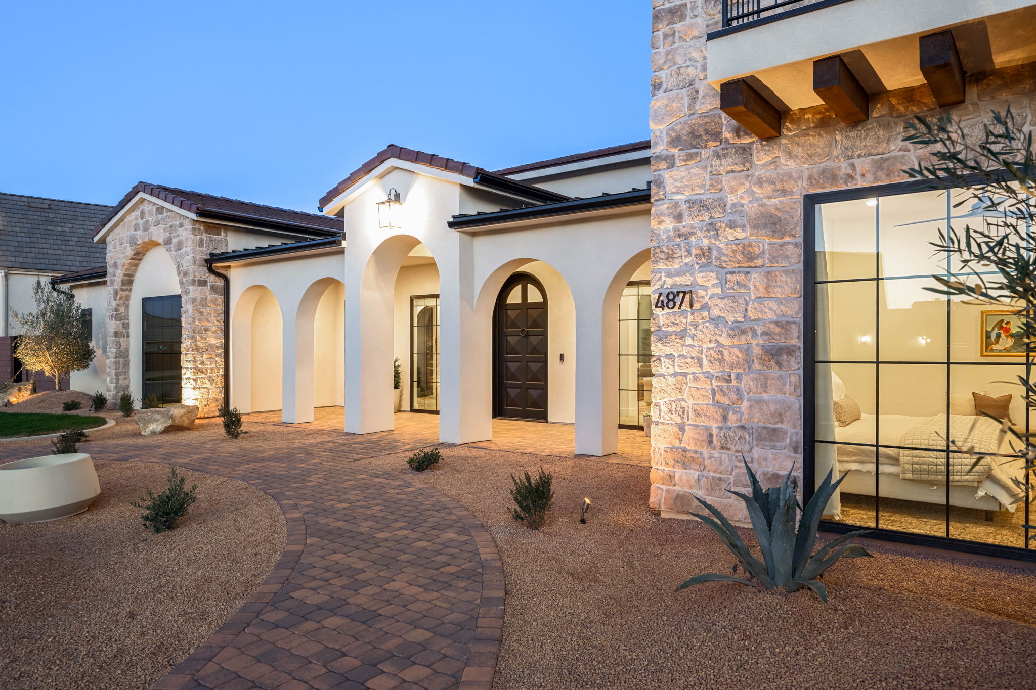 Property entrance with stone siding, stucco siding, and a tiled roof