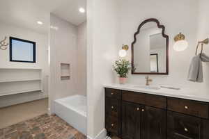 Full bath with vanity, stone finish floors, tub / shower combination, and recessed lighting