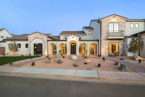 Mediterranean / spanish home with stone siding, stucco siding, and a balcony