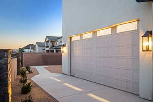 Garage at dusk with concrete driveway