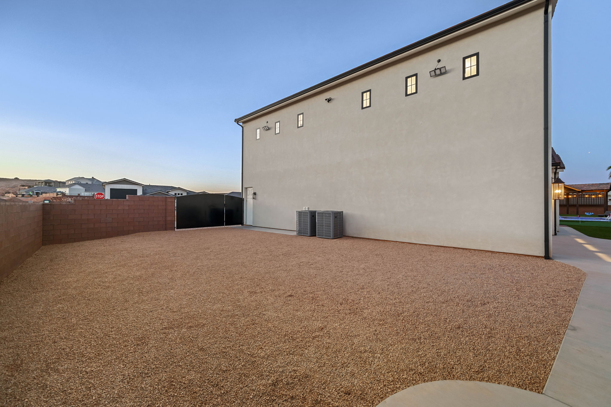 Property exterior at dusk with a fenced backyard and stucco siding