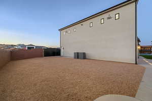 Property exterior at dusk with a fenced backyard and stucco siding
