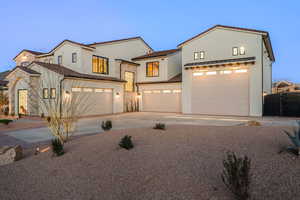 View of front of home featuring concrete driveway, stucco siding, and an attached garage