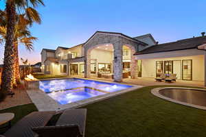 Rear view of property with a balcony, outdoor furniture, stone siding, a patio area, and stucco siding