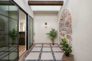 View of exterior entry with stucco siding and stone siding
