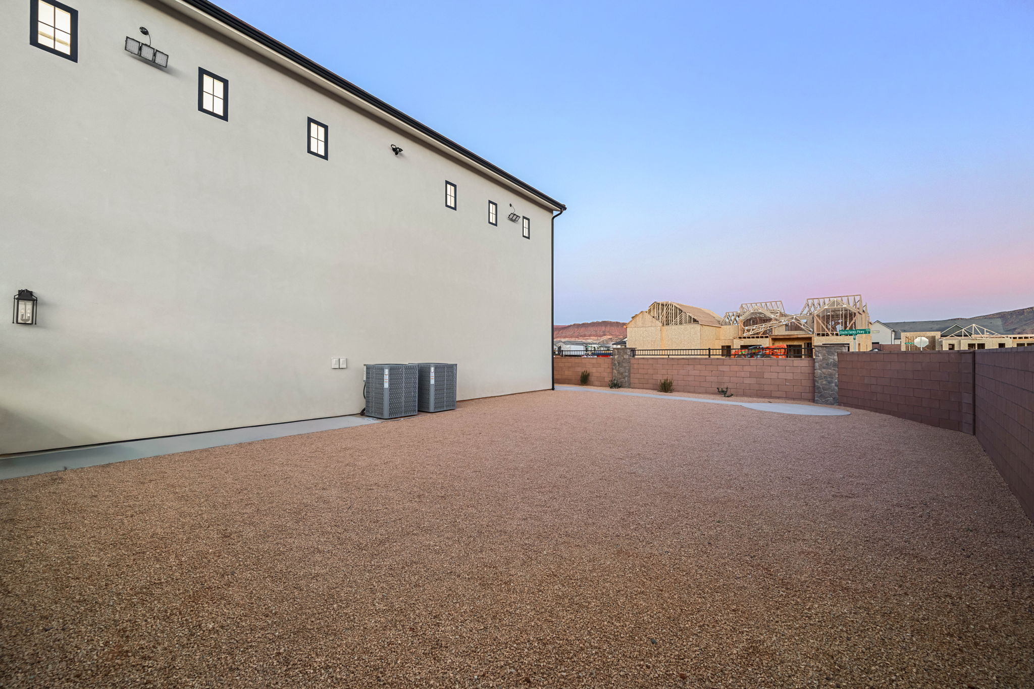 Property exterior at dusk featuring a fenced backyard and stucco siding