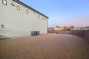 Property exterior at dusk featuring a fenced backyard and stucco siding