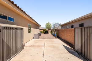 View of side of property with stucco siding, a patio, and a fenced backyard